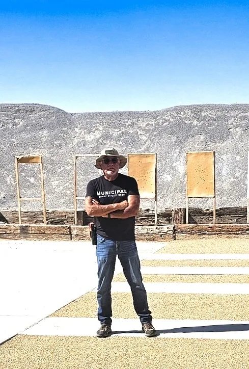 Man standing outdoors in casual attire.