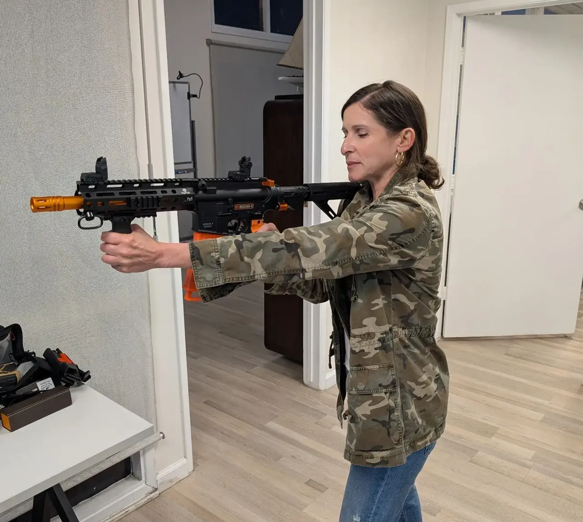 Person aiming toy gun in indoor setting.