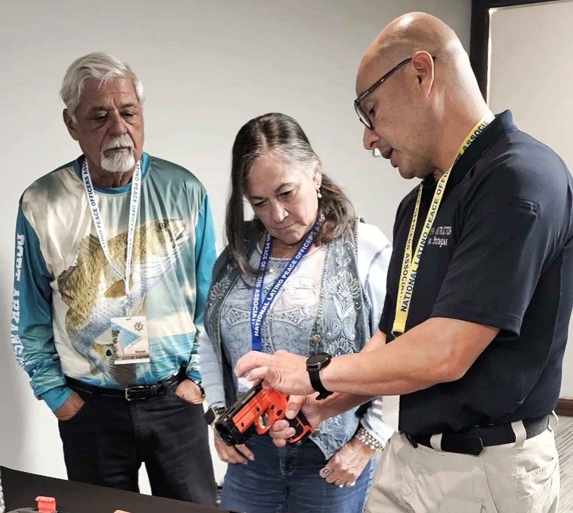 Three people examining a tool together.