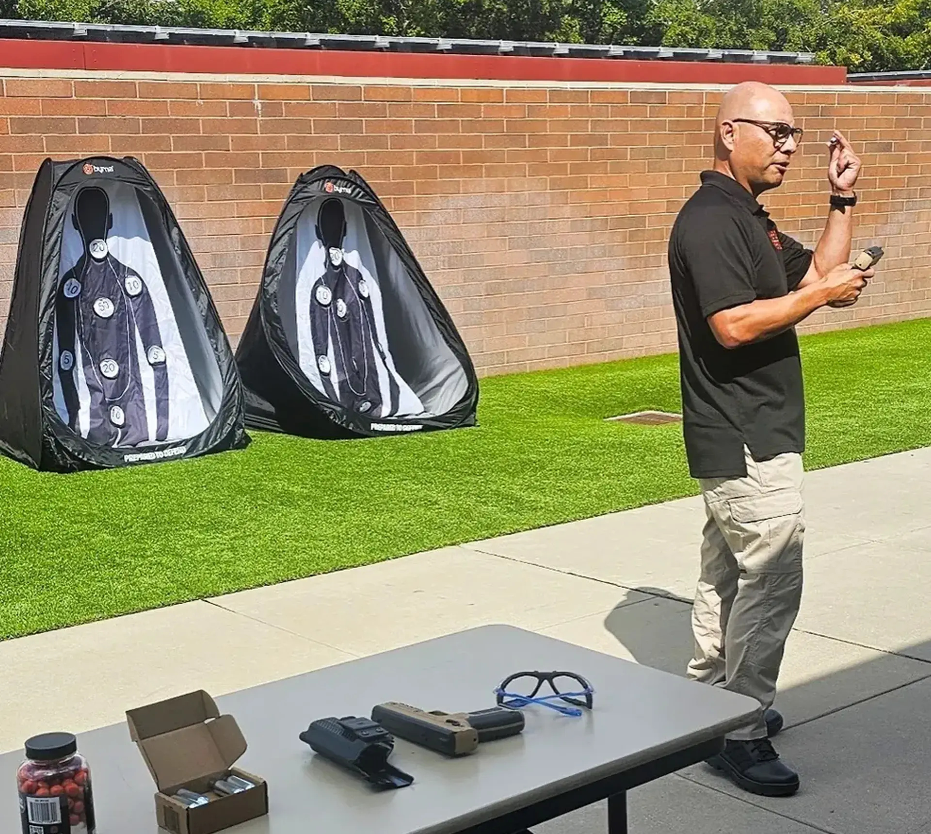 Man instructing at outdoor shooting range.