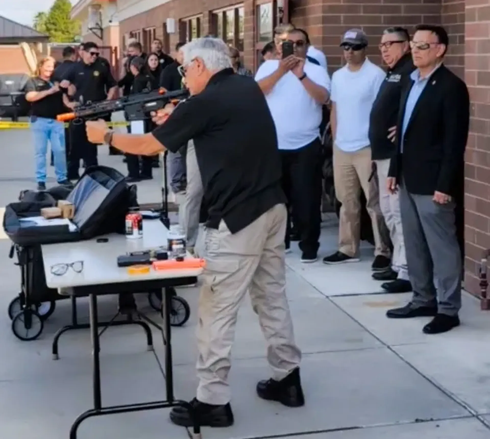 Man demonstrating a rifle to a crowd.