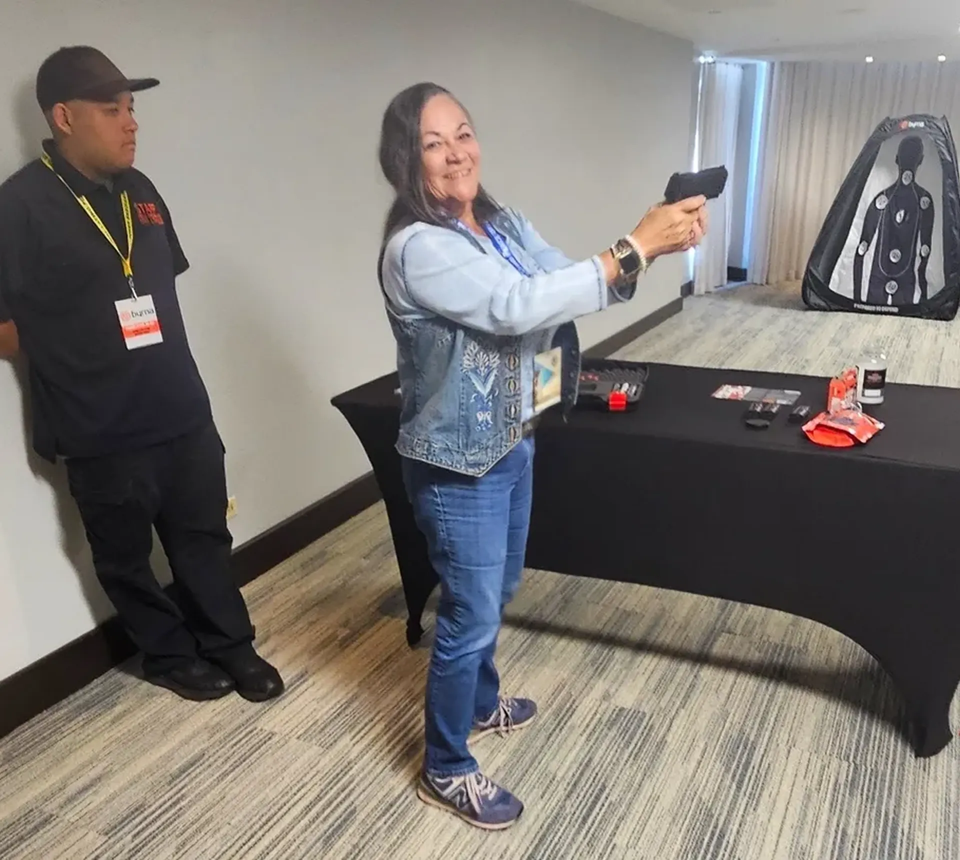 Woman aiming at target in training room.
