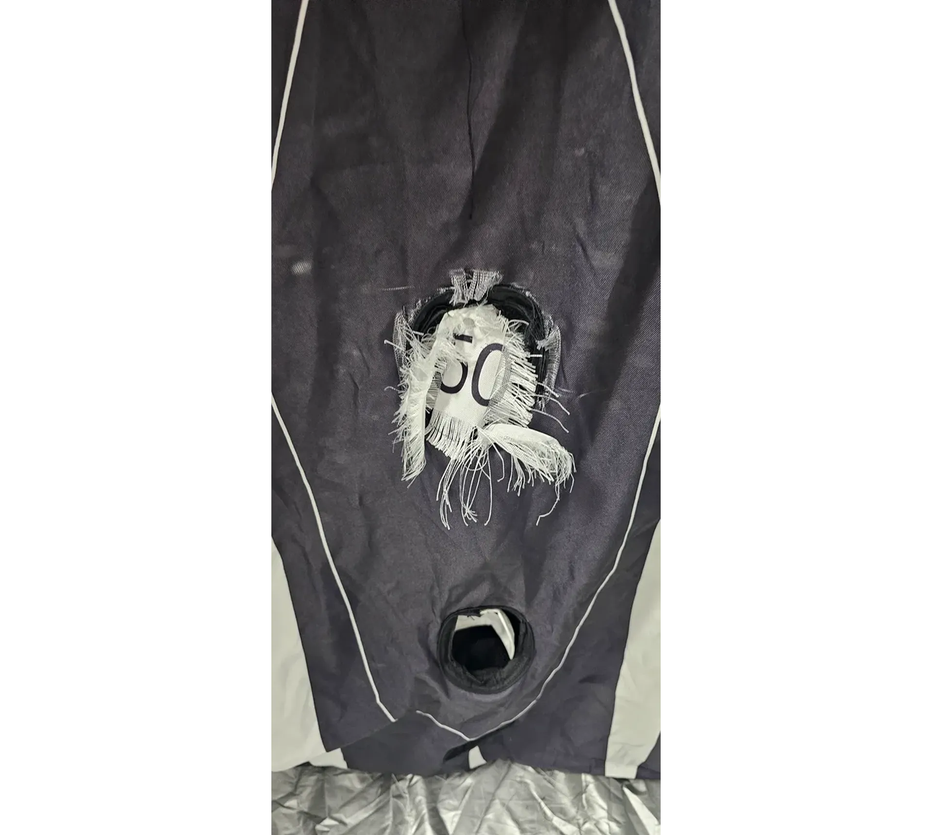 Ripped black fabric with circular tear.